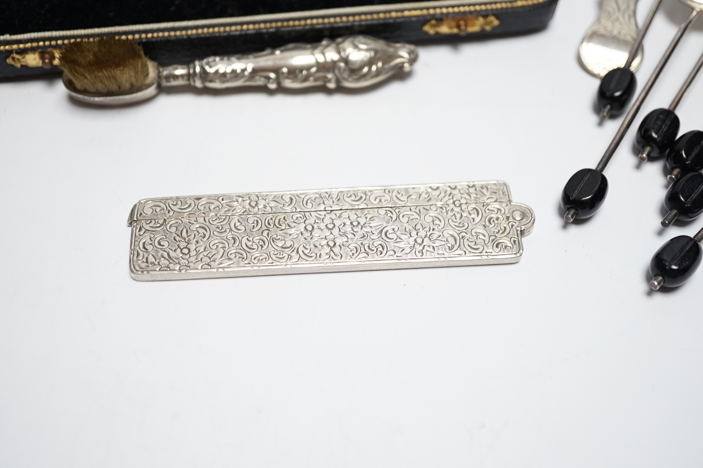 Sundry small silver including a Victorian caddy spoon, London, 1845, a folding comb, handled toothbrush and various coffee spoons.